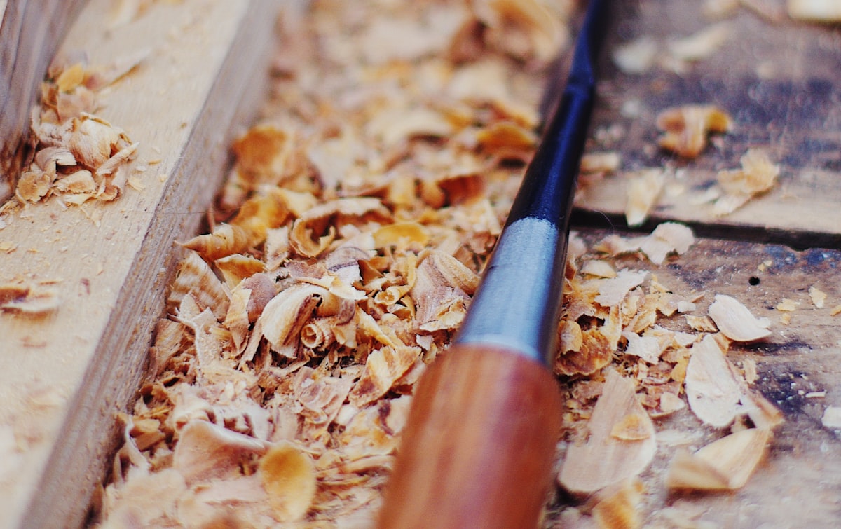 A chisel resting in fresh wood shavings on the bench