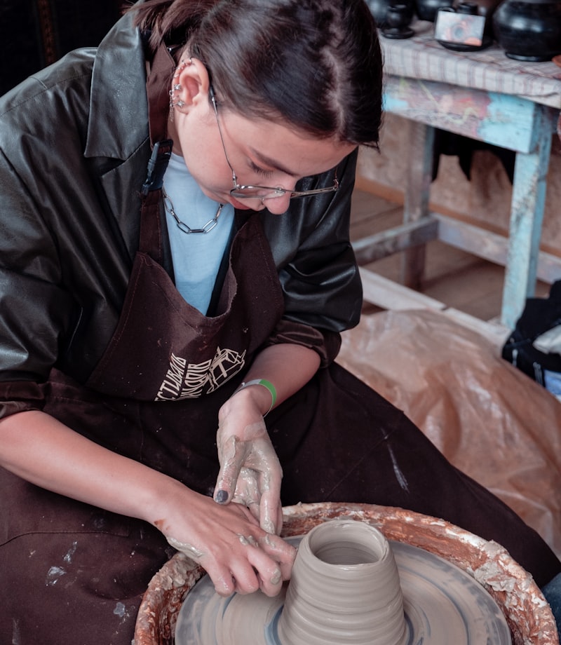 Erin working at the bench with a finished pot